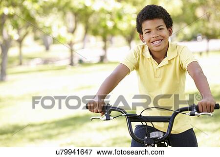 Boy cycling in park View Large Photo Image Stock Photo - Boy cycling in park. Fotosearch