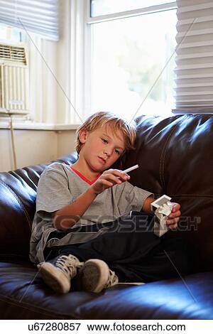 Stock Photo - Boy Discovering Parent's Pack Of Cigarettes At Home. Fotosearch
