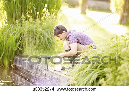 Picture - Boy Fishing In Pond With Net And Jar. Fotosearch