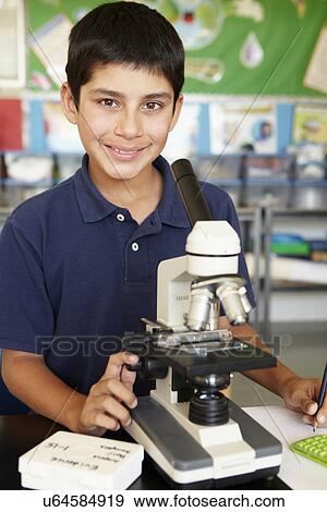 Stock Photo - Boy in science class with microscope. Fotosearch