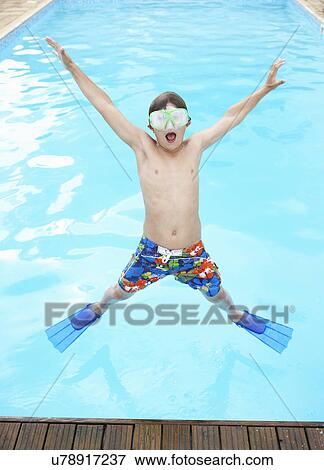 Boy jumping into outdoor swimming pool View Large Photo Image Stock Photo - Boy jumping into outdoor swimming pool. Fotosearch