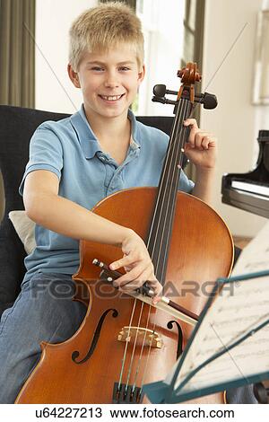 Stock Image - Boy playing cello at home. Fotosearch