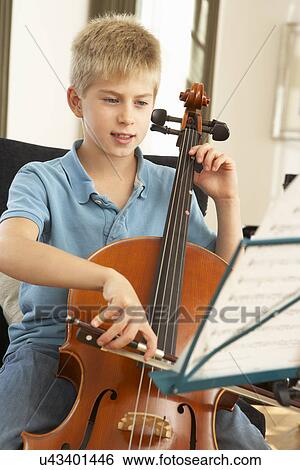 Stock Photograph - Boy playing cello at home. Fotosearch