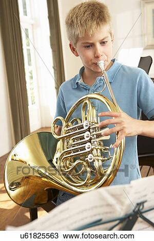 Boy playing French horn at home View Large Photo Image Stock Image - Boy playing French horn at home. Fotosearch