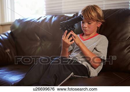 Boy Playing With Parent's Gun He Has Found At Home View Large Photo Image Stock Photograph - Boy Playing With Parent's Gun He Has Found At Home. Fotosearch
