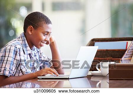 Boy Using Laptop On Desk At Home View Large Photo Image Stock Photography - Boy Using Laptop On Desk At Home. Fotosearch