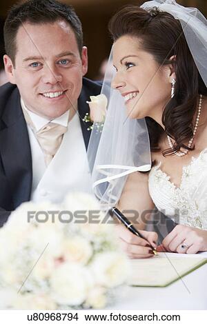 Picture - Bride And Groom Signing Wedding Register. Fotosearch