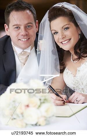 Stock Photography - Bride And Groom Signing Wedding Register. Fotosearch