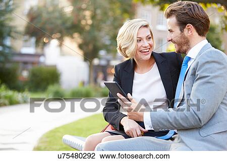 Business Couple Using Digital Tablet On Park Bench View Large Photo Image Stock Image - Business Couple Using Digital Tablet On Park Bench. Fotosearch
