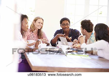 Stock Image - Business People Having Meeting And Eating Pizza . Fotosearch