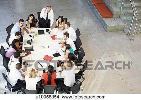 Picture - Businessman Addressing Meeting Around Boardroom Table. Fotosearch