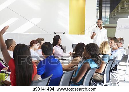Businessman Addressing Meeting Around Boardroom Table View Large Photo Image Picture - Businessman Addressing Meeting Around Boardroom Table. Fotosearch