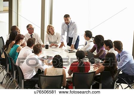 Businessman Addressing Meeting Around Boardroom Table View Large Photo Image Stock Image - Businessman Addressing Meeting Around Boardroom Table. Fotosearch