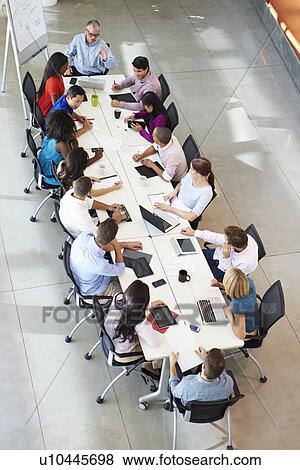 Businessman Addressing Meeting Around Boardroom Table View Large Photo Image Stock Photo - Businessman Addressing Meeting Around Boardroom Table. Fotosearch