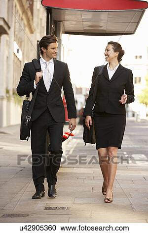 Businessman and businesswoman walking in street View Large Photo Image Stock Image - Businessman and businesswoman walking in street. Fotosearch