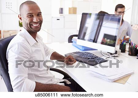 Businessman At Computer In Office Of Start Up Business View Large Photo Image Stock Image - Businessman At Computer In Office Of Start Up Business. Fotosearch
