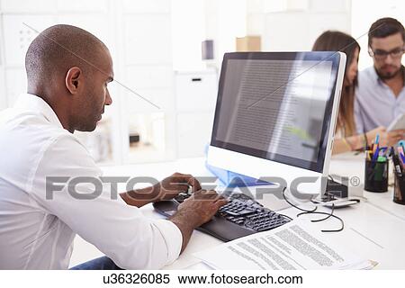 Businessman At Computer In Office Of Start Up Business View Large Photo Image Stock Photography - Businessman At Computer In Office Of Start Up Business. Fotosearch