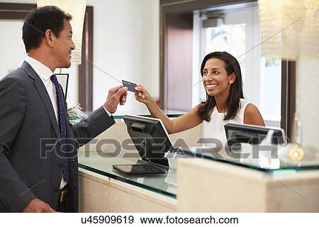 Businessman Checking In At Hotel Reception Front Desk View Large Photo Image Stock Photo - Businessman Checking In At Hotel Reception Front Desk. Fotosearch