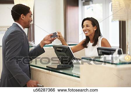 Businessman Checking In At Hotel Reception Front Desk View Large Photo Image Stock Photograph - Businessman Checking In At Hotel Reception Front Desk. Fotosearch