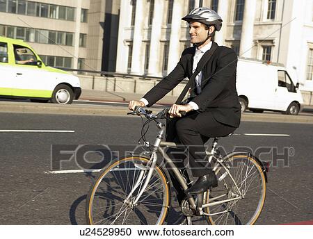 Stock Image - Businessman cycling to work. Fotosearch