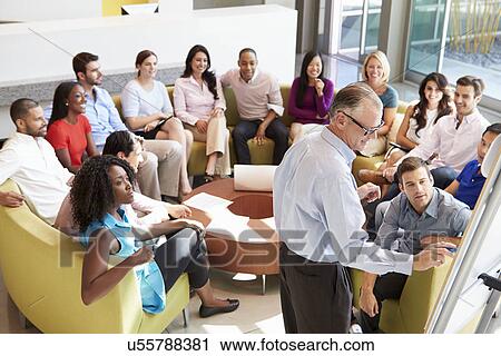 Stock Image - Businessman Making Presentation To Office Colleagues. Fotosearch