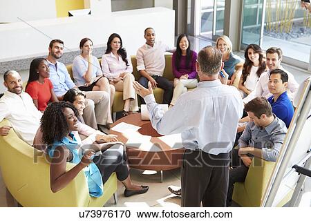 Stock Image - Businessman Making Presentation To Office Colleagues. Fotosearch