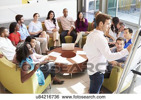 Stock Photograph - Businessman Making Presentation To Office Colleagues. Fotosearch