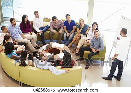 Stock Photography - Businessman Making Presentation To Office Colleagues. Fotosearch