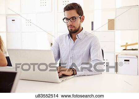Picture - Businessman Using Laptop In Office Of Start Up Business. Fotosearch