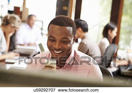 Businessman Working At Desk Using Mobile Phone View Large Photo Image Stock Photo - Businessman Working At Desk Using Mobile Phone. Fotosearch