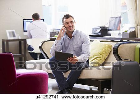 Businessman Working On Digital Tablet In Hotel Lobby View Large Photo Image Stock Image - Businessman Working On Digital Tablet In Hotel Lobby. Fotosearch
