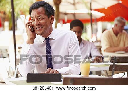 Businessman Working On Digital Tablet In Outdoor Cafe View Large Photo Image Stock Image - Businessman Working On Digital Tablet In Outdoor Cafe. Fotosearch