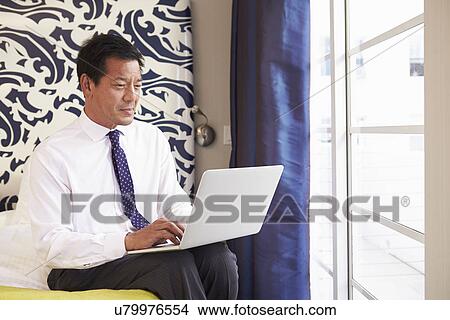 Businessman Working On Laptop In Hotel Room View Large Photo Image Picture - Businessman Working On Laptop In Hotel Room. Fotosearch