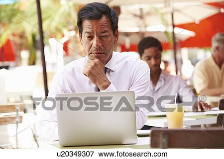Stock Photo - Businessman Working On Laptop In Outdoor Cafe. Fotosearch