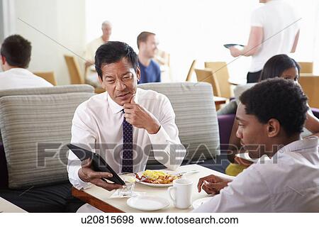Stock Photo - Businessmen Meeting Over Breakfast In Hotel Restaurant. Fotosearch