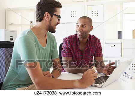Stock Photo - Businessmen Using Laptop In Office Of Start Up Business. Fotosearch