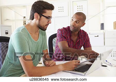 Stock Photography - Businessmen Using Laptop In Office Of Start Up Business. Fotosearch
