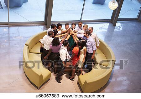 Stock Photo - Businesspeople Giving Each Other High Five In Office Lobby. Fotosearch