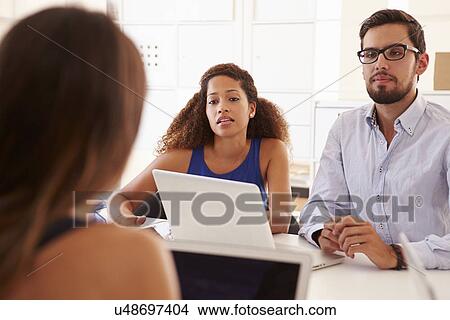 Picture - Businesspeople Using Laptop In Office Of Start Up Business. Fotosearch