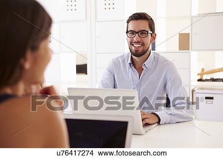 Picture - Businesspeople Using Laptop In Office Of Start Up Business. Fotosearch