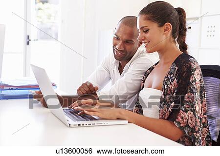 Businesspeople Using Laptop In Office Of Start Up Business View Large Photo Image Stock Photograph - Businesspeople Using Laptop In Office Of Start Up Business. Fotosearch