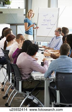 Businesswoman Addressing Meeting Around Boardroom Table View Large Photo Image Picture - Businesswoman Addressing Meeting Around Boardroom Table. Fotosearch