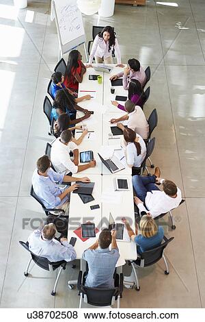 Businesswoman Addressing Meeting Around Boardroom Table View Large Photo Image Stock Photo - Businesswoman Addressing Meeting Around Boardroom Table. Fotosearch