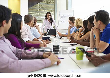 Businesswoman Addressing Meeting Around Boardroom Table View Large Photo Image Stock Photo - Businesswoman Addressing Meeting Around Boardroom Table. Fotosearch