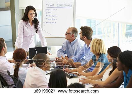 Businesswoman Addressing Meeting Around Boardroom Table View Large Photo Image Stock Photo - Businesswoman Addressing Meeting Around Boardroom Table. Fotosearch
