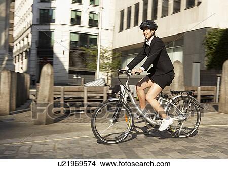 Picture - Businesswoman cycling to work. Fotosearch