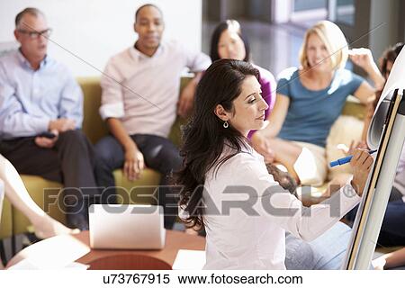 Stock Photography - Businesswoman Making Presentation To Office Colleagues. Fotosearch