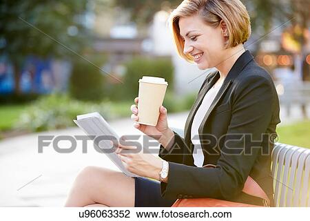 Businesswoman On Park Bench With Coffee Using Digital Tablet View Large Photo Image Stock Image - Businesswoman On Park Bench With Coffee Using Digital Tablet. Fotosearch