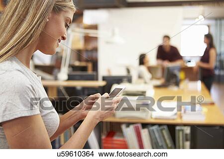 Businesswoman Using Mobile Phone In Modern Office View Large Photo Image Picture - Businesswoman Using Mobile Phone In Modern Office. Fotosearch