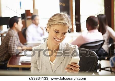 Businesswoman Working At Desk Using Mobile Phone View Large Photo Image Stock Image - Businesswoman Working At Desk Using Mobile Phone. Fotosearch